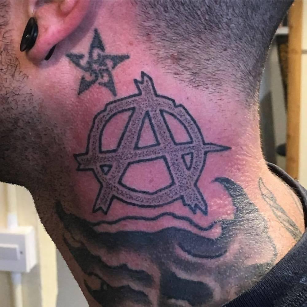 Photo of anarchy tattoo on the head.
