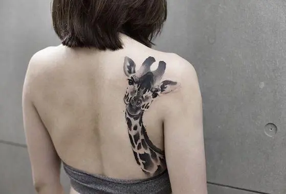 Li ser milê keçikek tattooê girafek xweşik