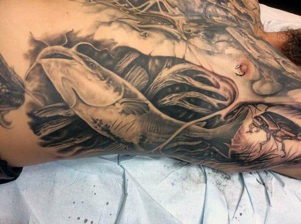 Большая татуировка сом на боку у мужчины