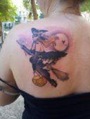 Татуировка ведьма с метлой на спине у девушки