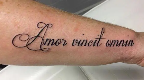 Inscripción de tatuaje "El amor gana"