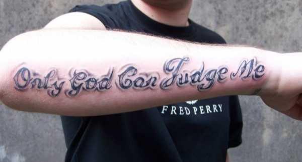 Inscripții despre tatuaje despre Dumnezeu pe mâna unui tip cu umbră