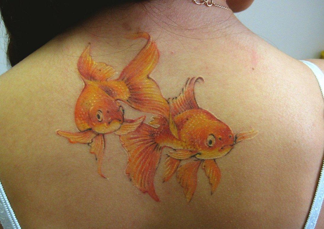 тату с золотыми рыбками на спине