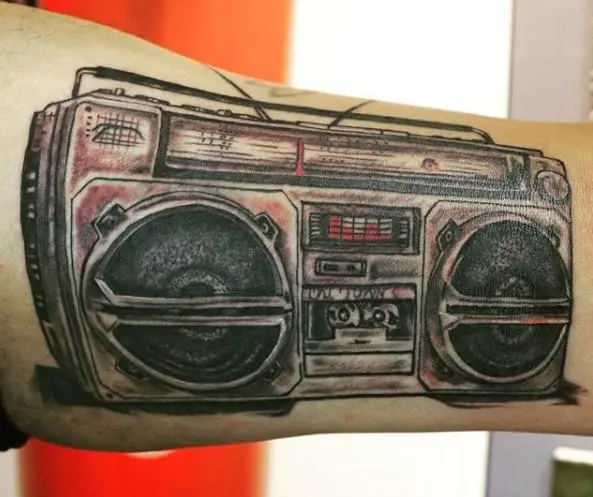 large tattoo with a tape recorder on the arm