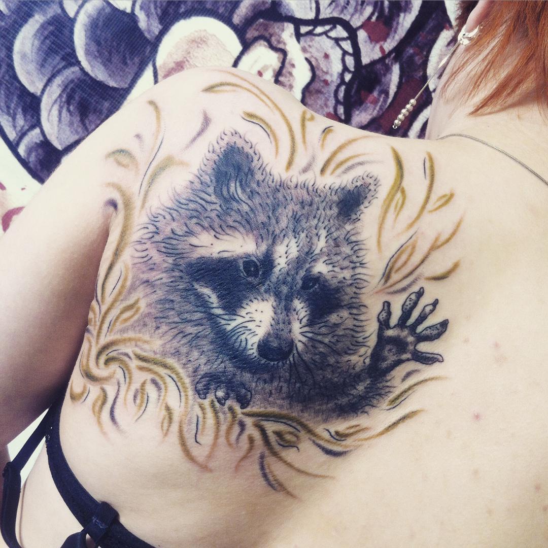 Photo of raccoon tattoo on body.