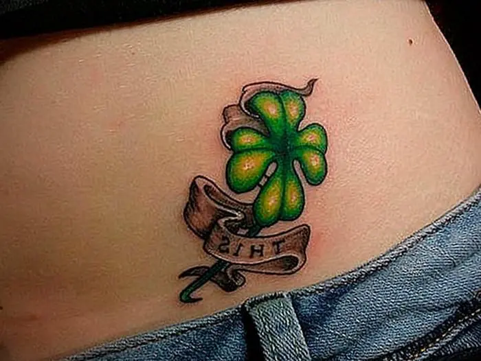 clover tattoo with lettering on the back back