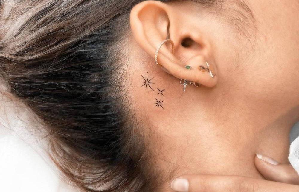 Татуювання зірки за вухом у дівчини