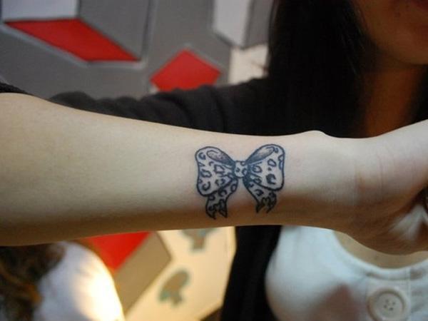 Man de rapaza de arco de tatuaxe