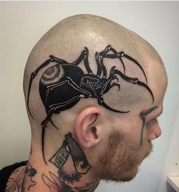 Photo of a spider tattoo on the head.