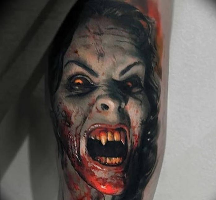 Photo of a tattoo with vampires on the leg.