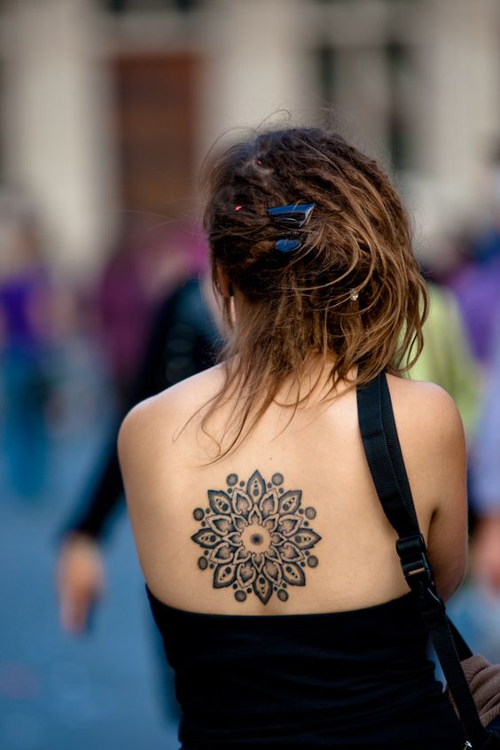 Images of mandalas in back tattoos.